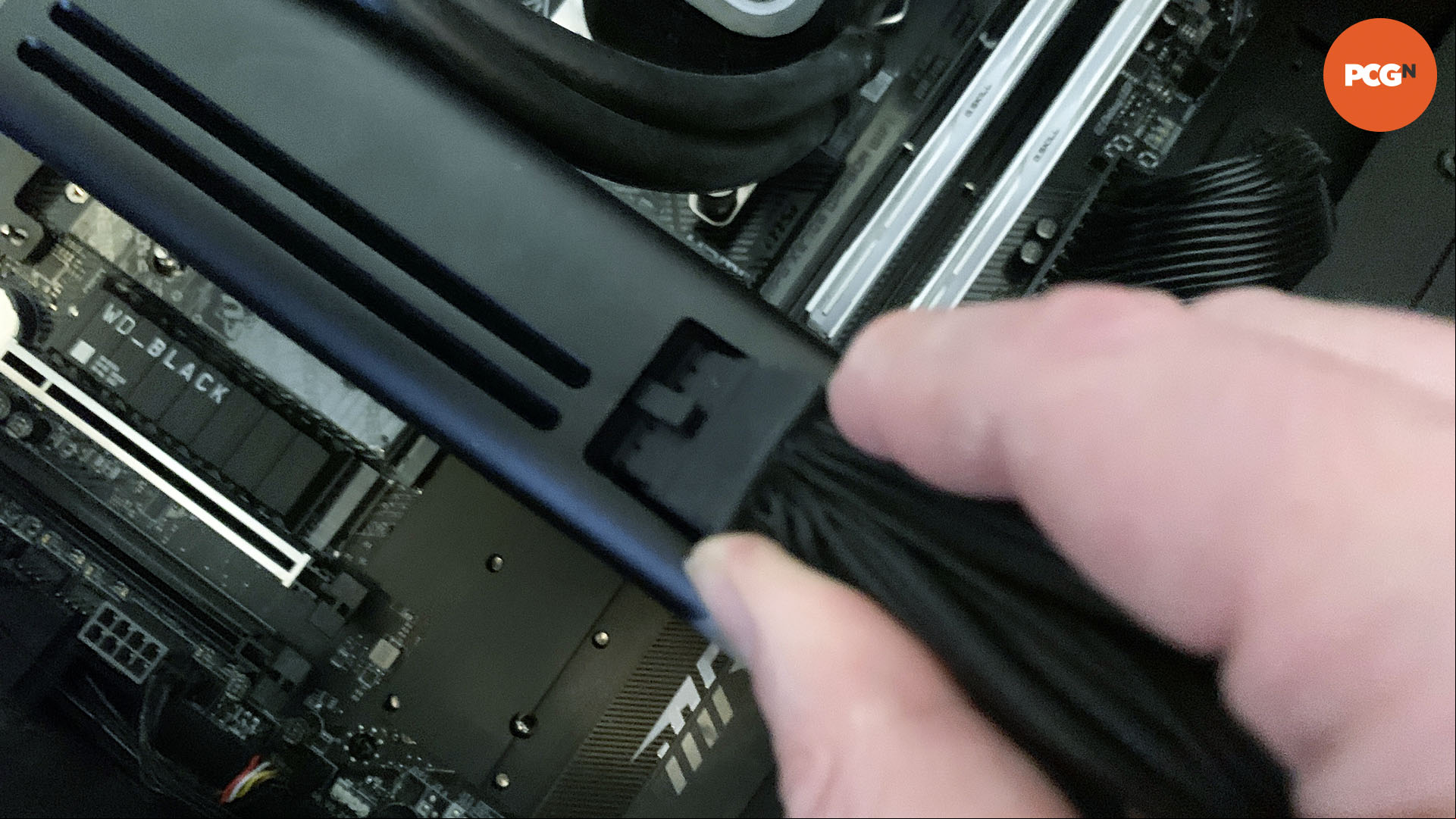 How to install a graphics card: Plug 16-pin 12VHPWR cable into Nvidia GeForce RTX 5090.