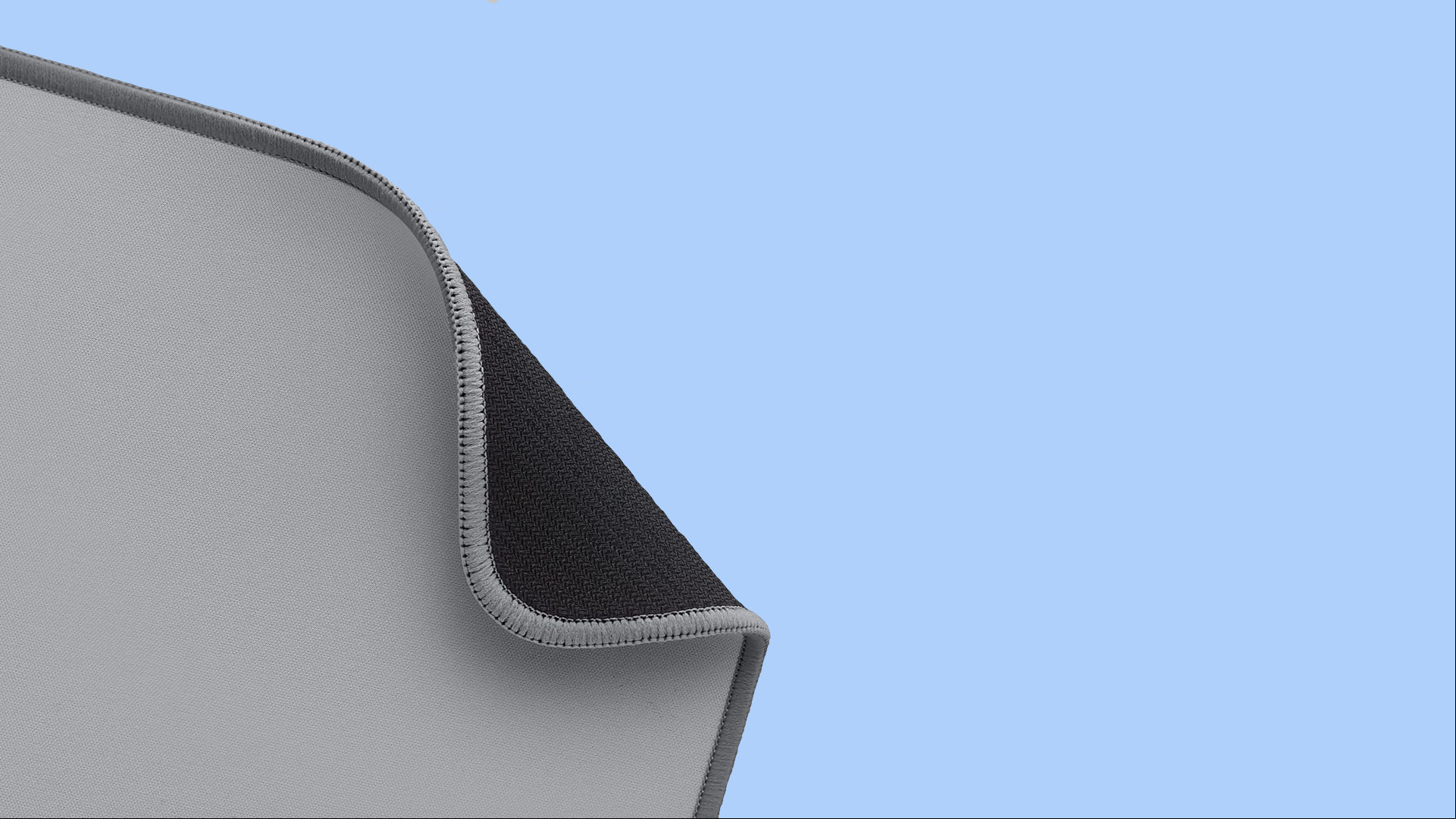 Hard vs soft mouse pad gaming: a partly unfurled soft gaming mouse pad on a blue background