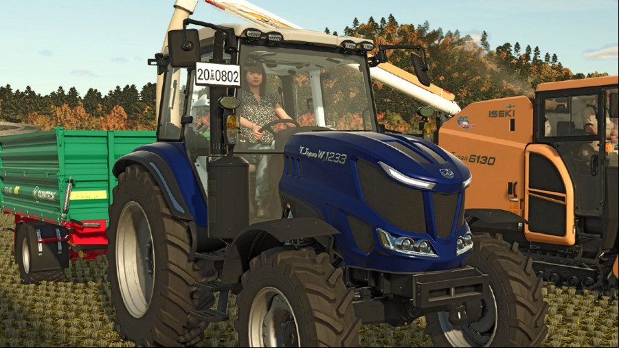 Farming Simulator 25: A woman driving a dark blue tractor towing a green trailer